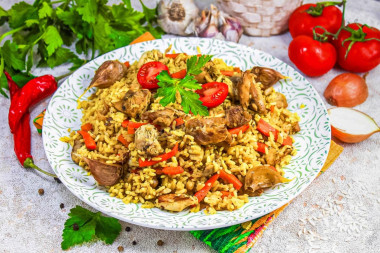 Рассыпчатый плов с курицей в кастрюле на плите